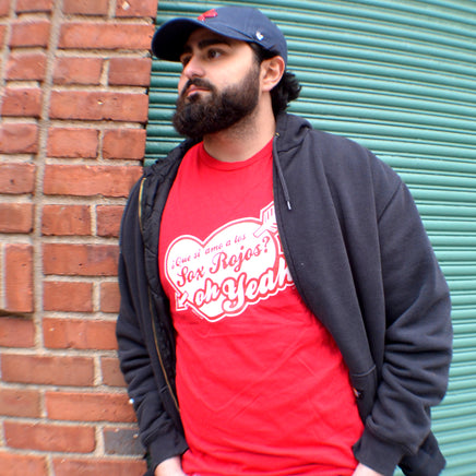 photograph of man in front of fenway park wearing spanglish red sox the red seat design white lettering on red unisex t-shirt